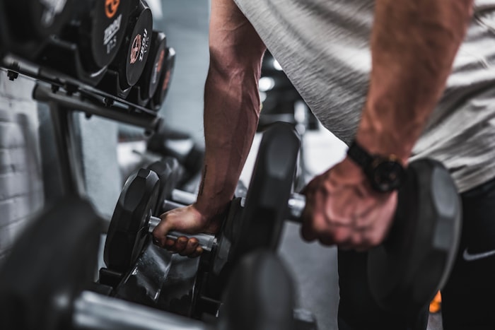 Rhea, the founder, hands on the dumbbell rack on the gym floor