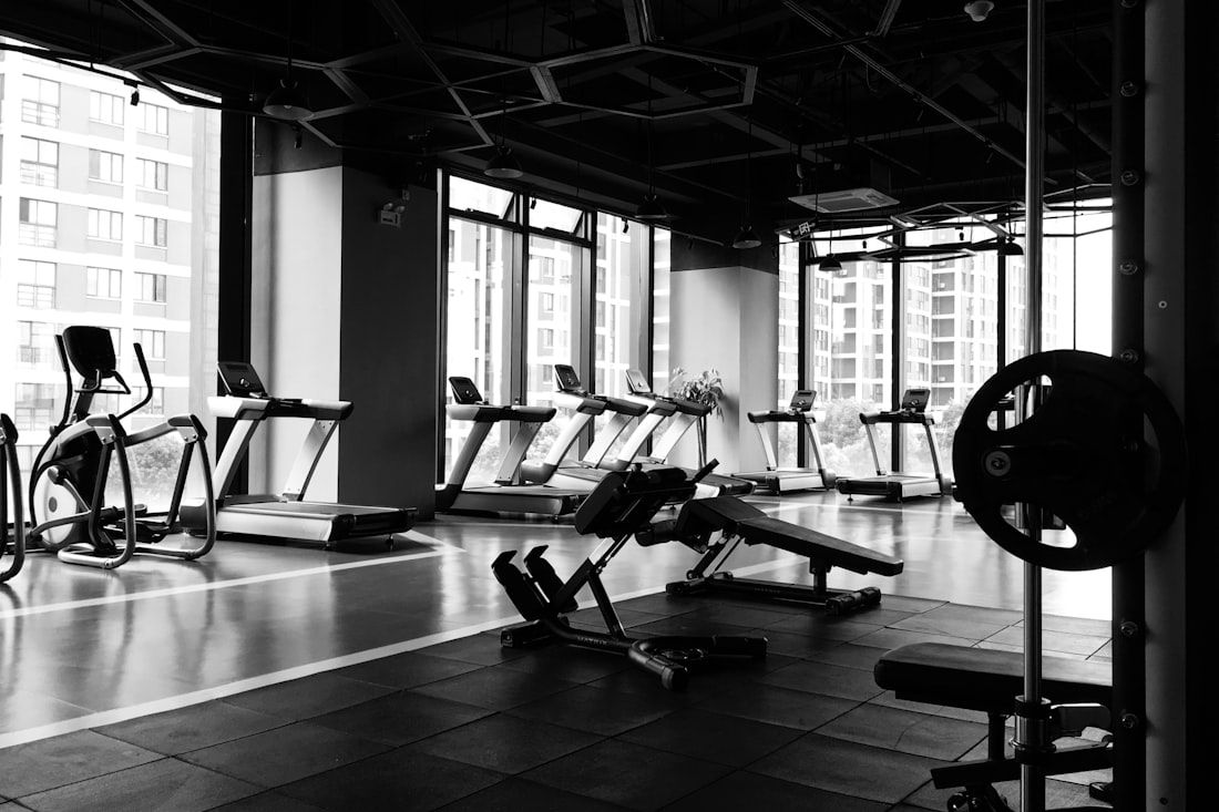 The gym floor: racks, benches, and equipment under hard light